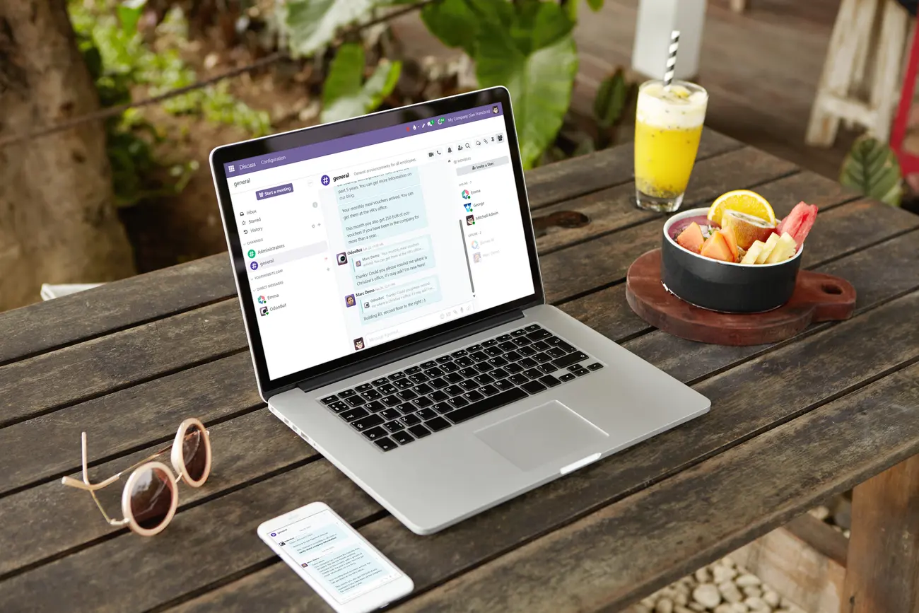 An outdoor table with a computer and a cell phone demonstrating how apps communicate between the two devices